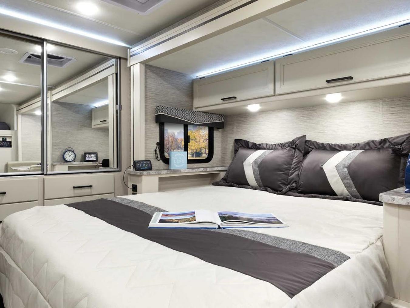Bedroom inside a Thor RV with neutral bedding