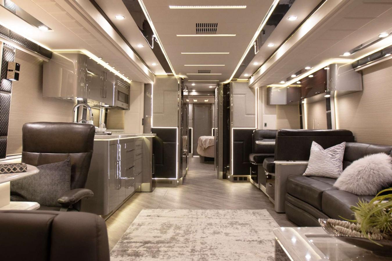 An interior shot of a taupe-themed living area inside of an Emerald Luxury Coach RV