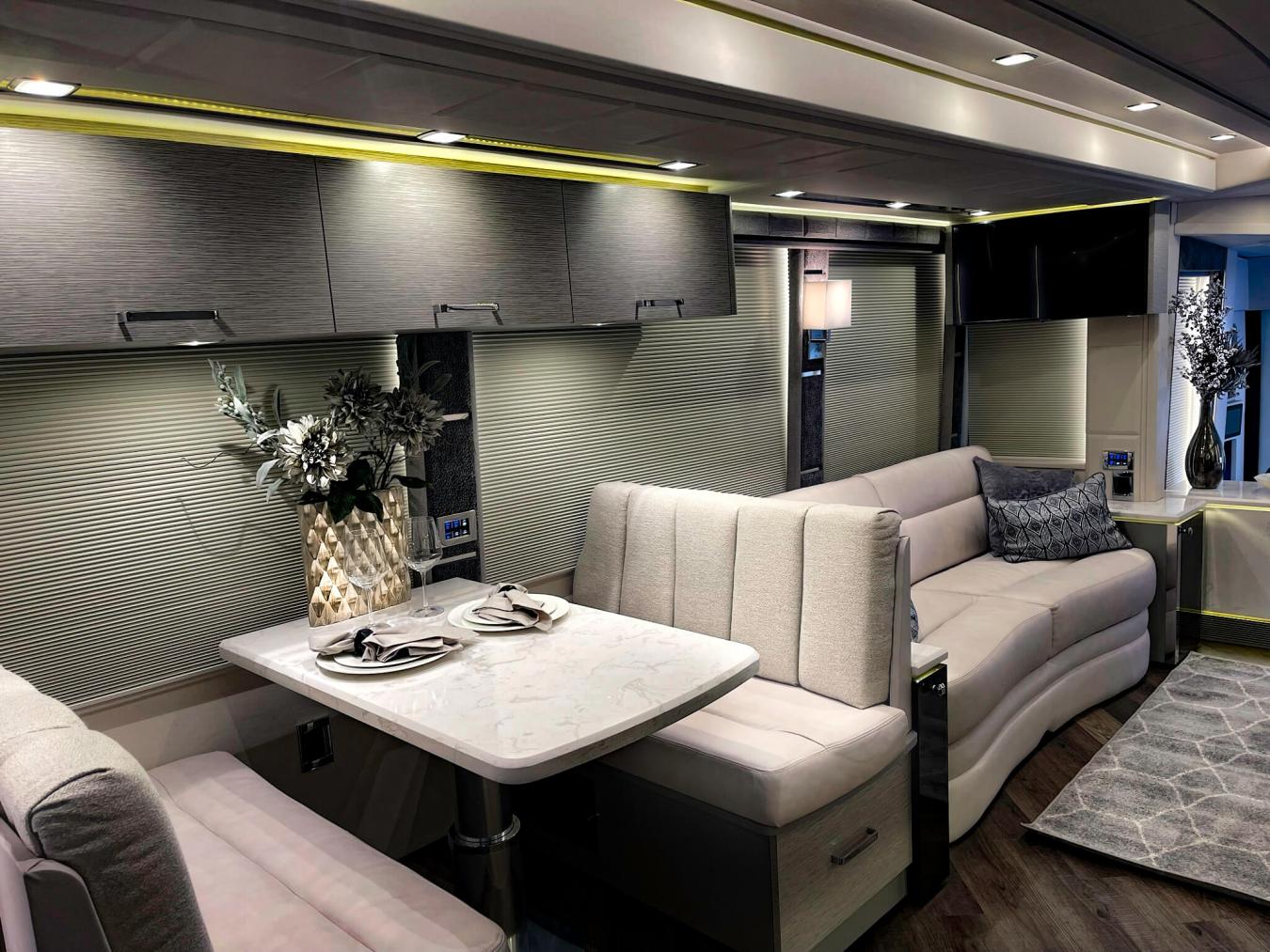 An interior shot of Emerald Luxury Coach RV with a taupe-colored seating area