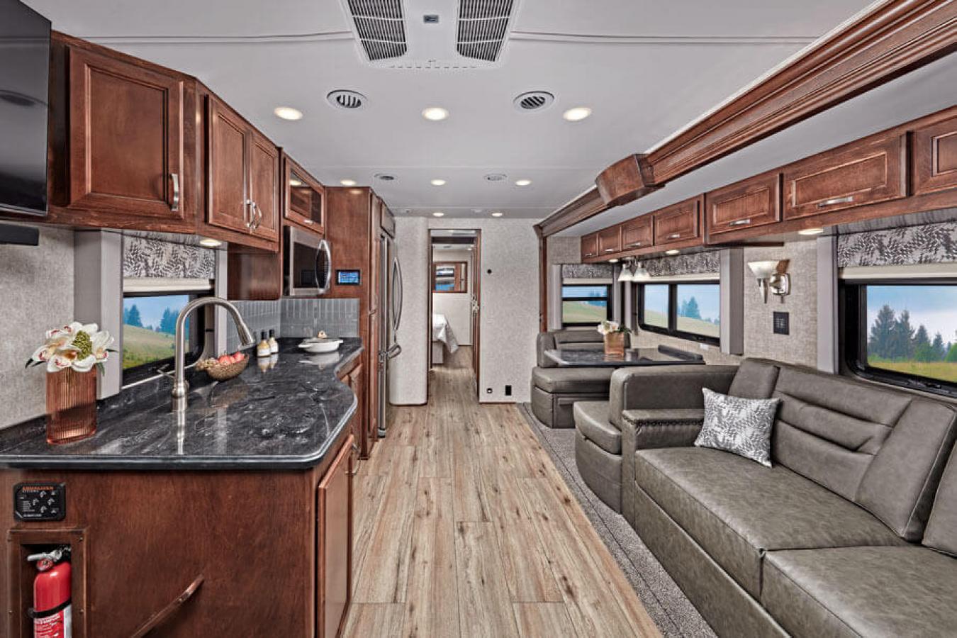 Interior view of a Renegade RV&#039;s living space including black countertops and brown cabinets