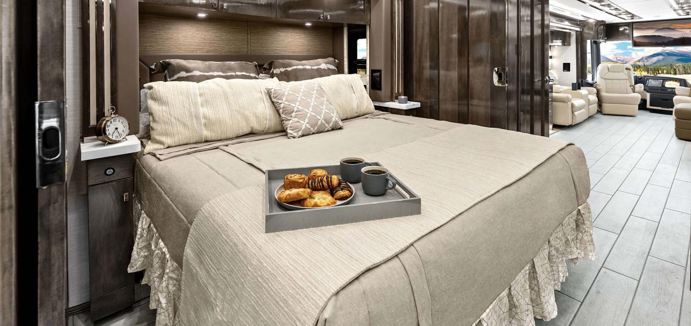 An interior shot of a breakfast tray on a bed inside of a Tiffin RV