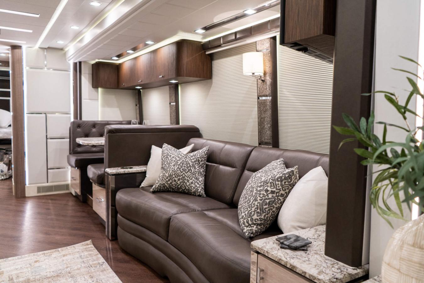 An interior shot of Emerald Luxury Coach RV with brown cabinets and a brown seating area