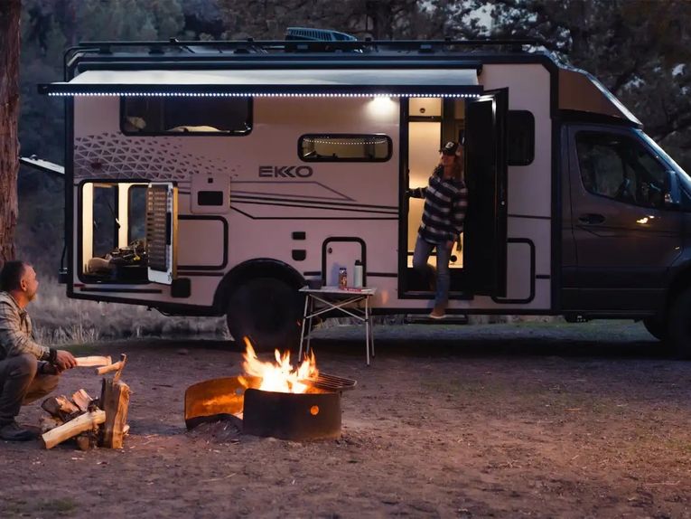 Couple enjoys a fire outside an RV