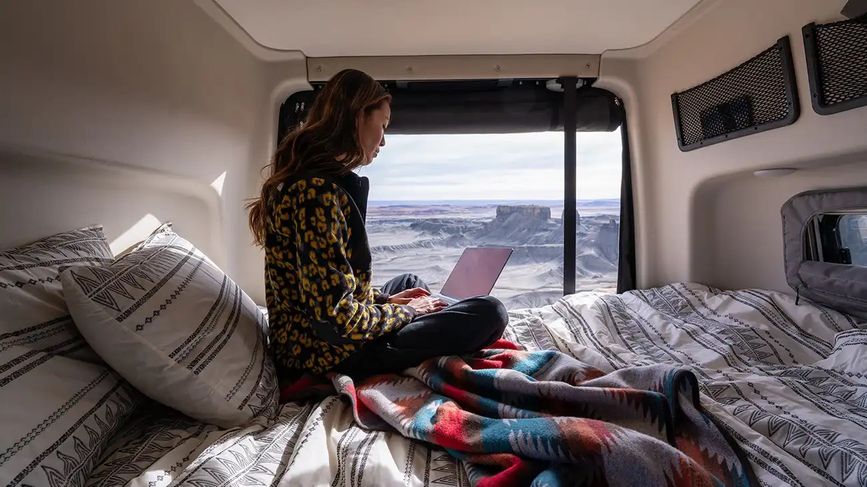 Person on the bed inside the Revel, looking out over a cold landscape
