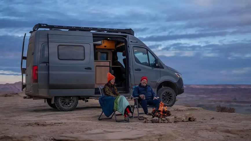 Two people beside a fire pit next to the Revel