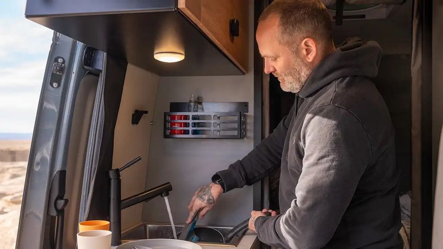 Person cooking in the Winnebago Revel
