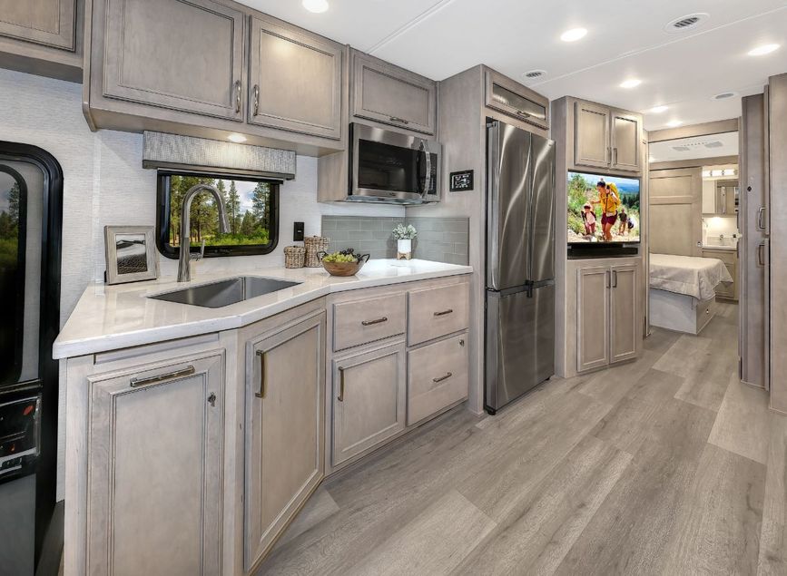 2026 Renegade Verona kitchen with refrigerator, stainless sink, convection microwave, and ample cabinetry.