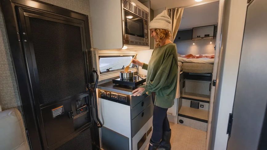 Woman cooking in the galley of the 2026 EKKO