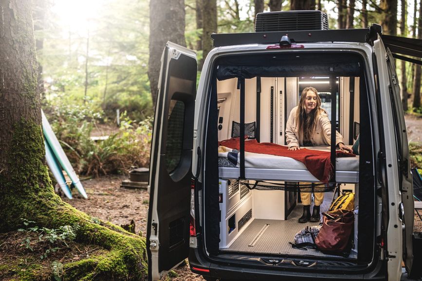 A traveler sets up her bed in the Tiffin GH1