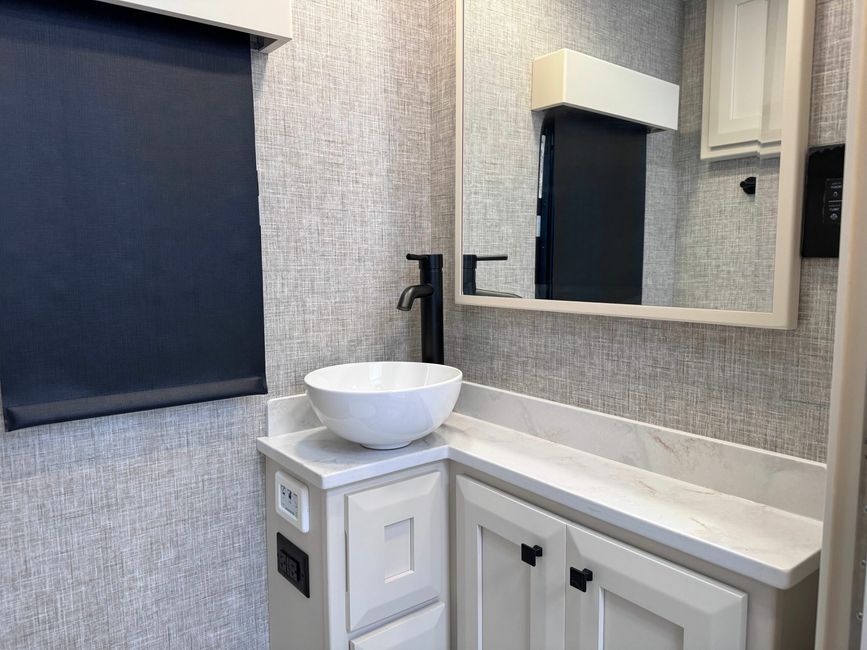 Mirror and bathroom sink in the Tiffin Midas