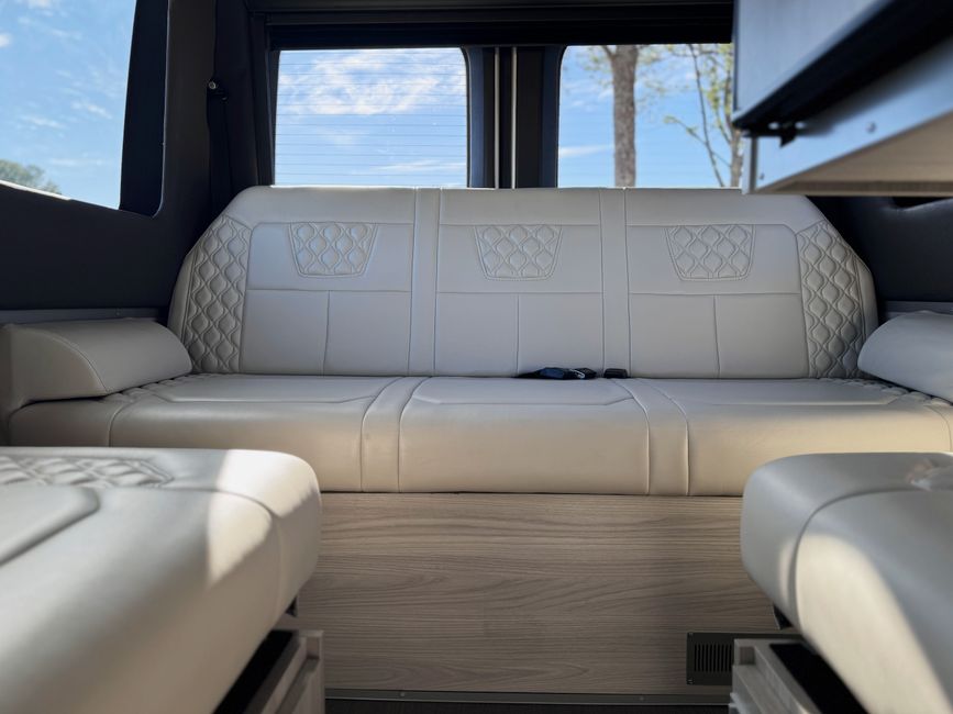 Interior lounge seating inside the 2026 Tiffin GT1 Touring Van with wraparound bench cushions
