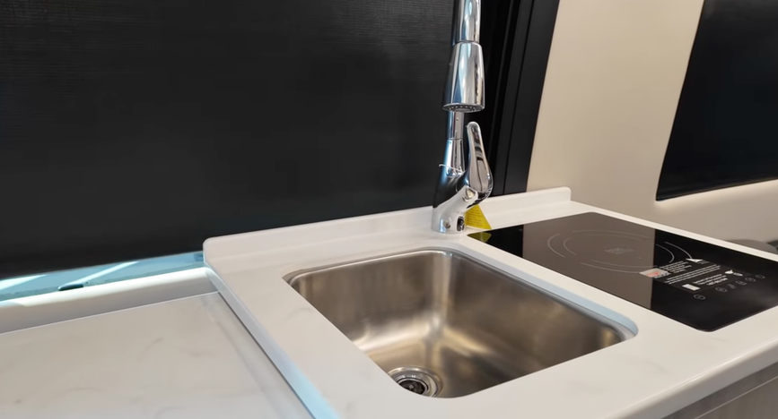 Interior galley of the 2026 Tiffin GT1 Touring Van showing the sink, cooktop, and counter space
