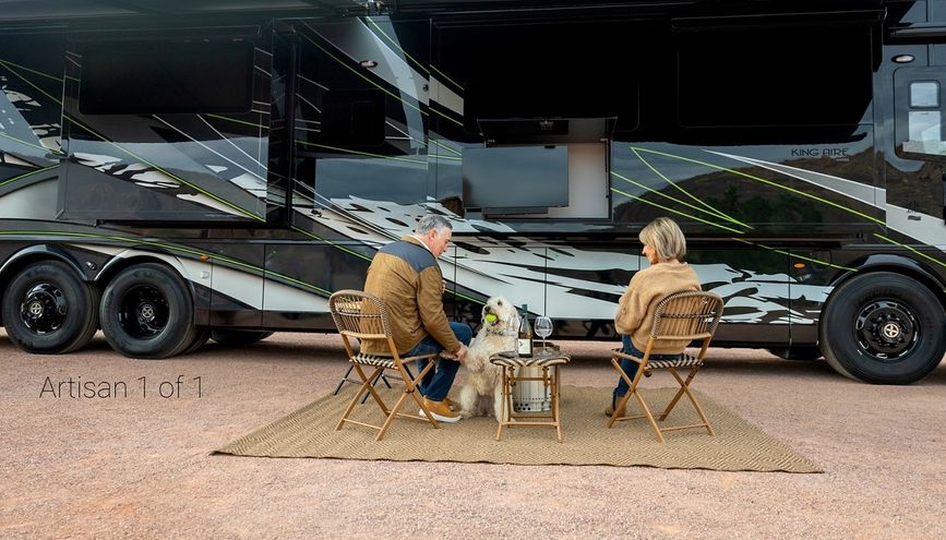 Exterior image with two people sitting outside of the 2027 Newmar King Aire