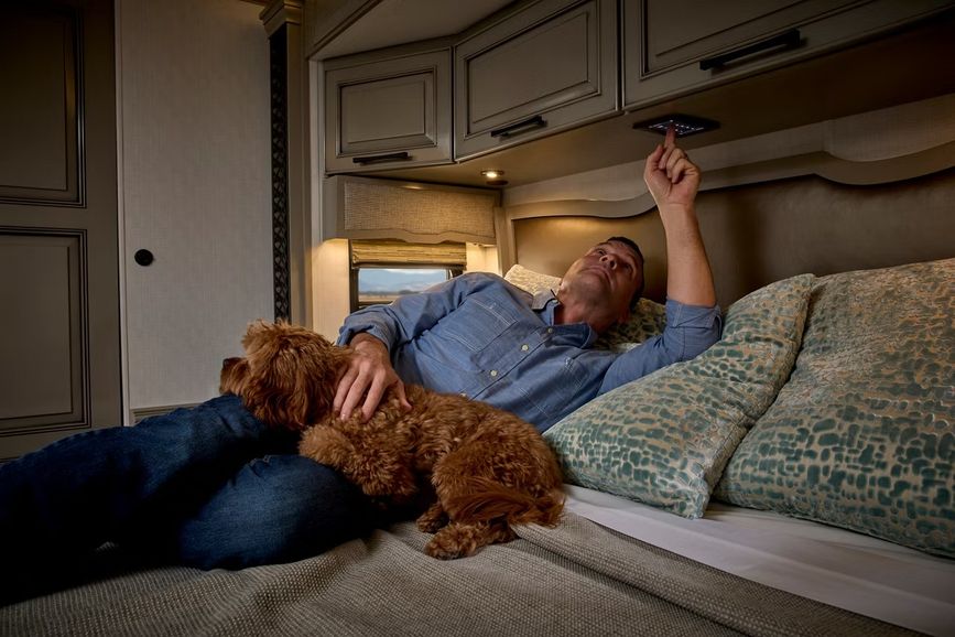 Man and dog on a bed inside an RV
