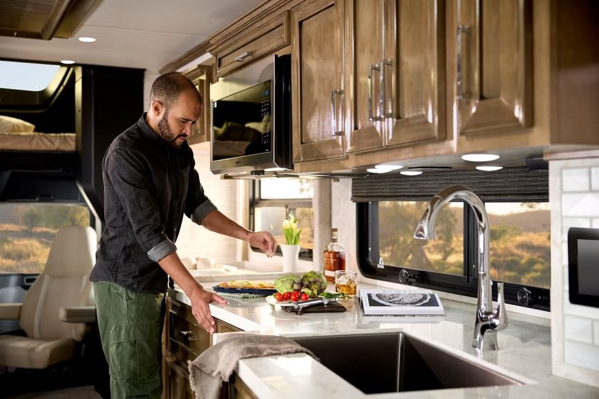 Man inside an RV kitchen