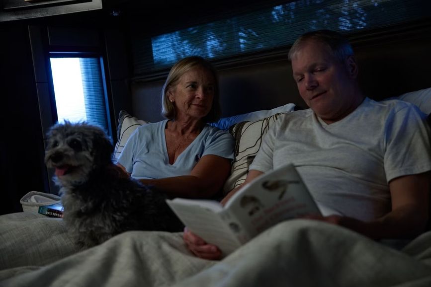 Two people and a dog inside the bedroom of the 2027 Newmar New Aire