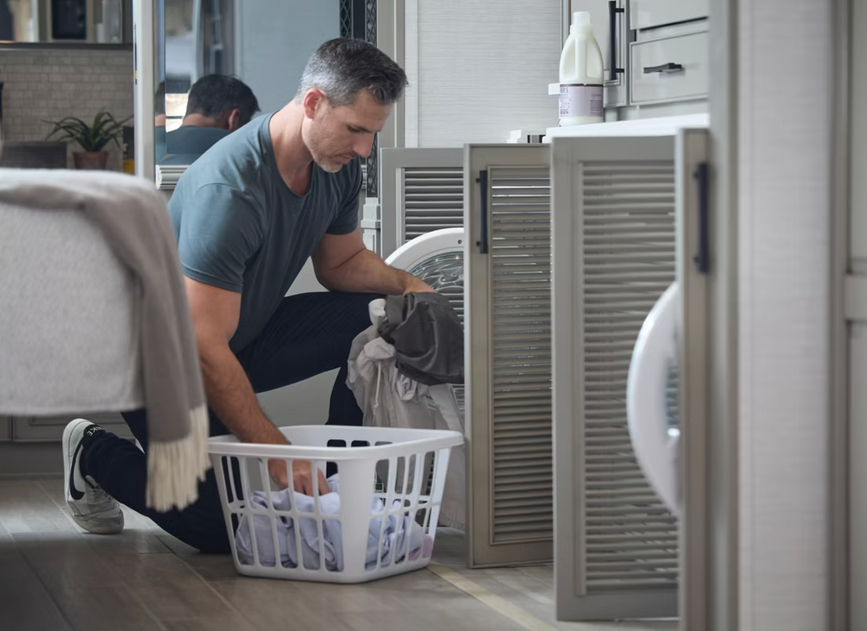A man does laundry in the 2026 Newmar Summit Aire