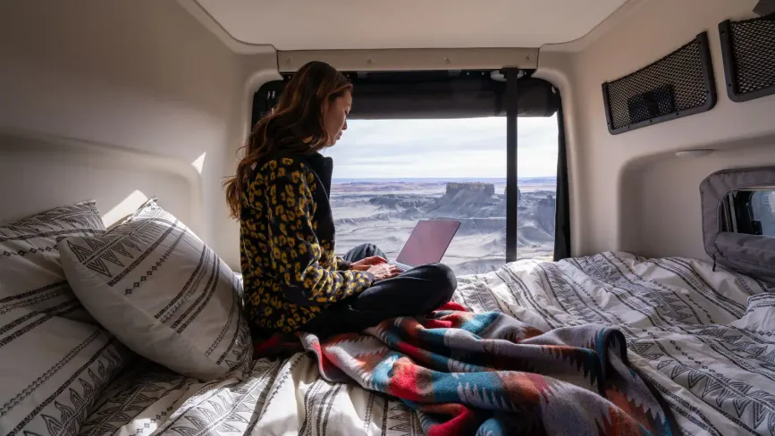 Passenger using a laptop in bed in the Revel