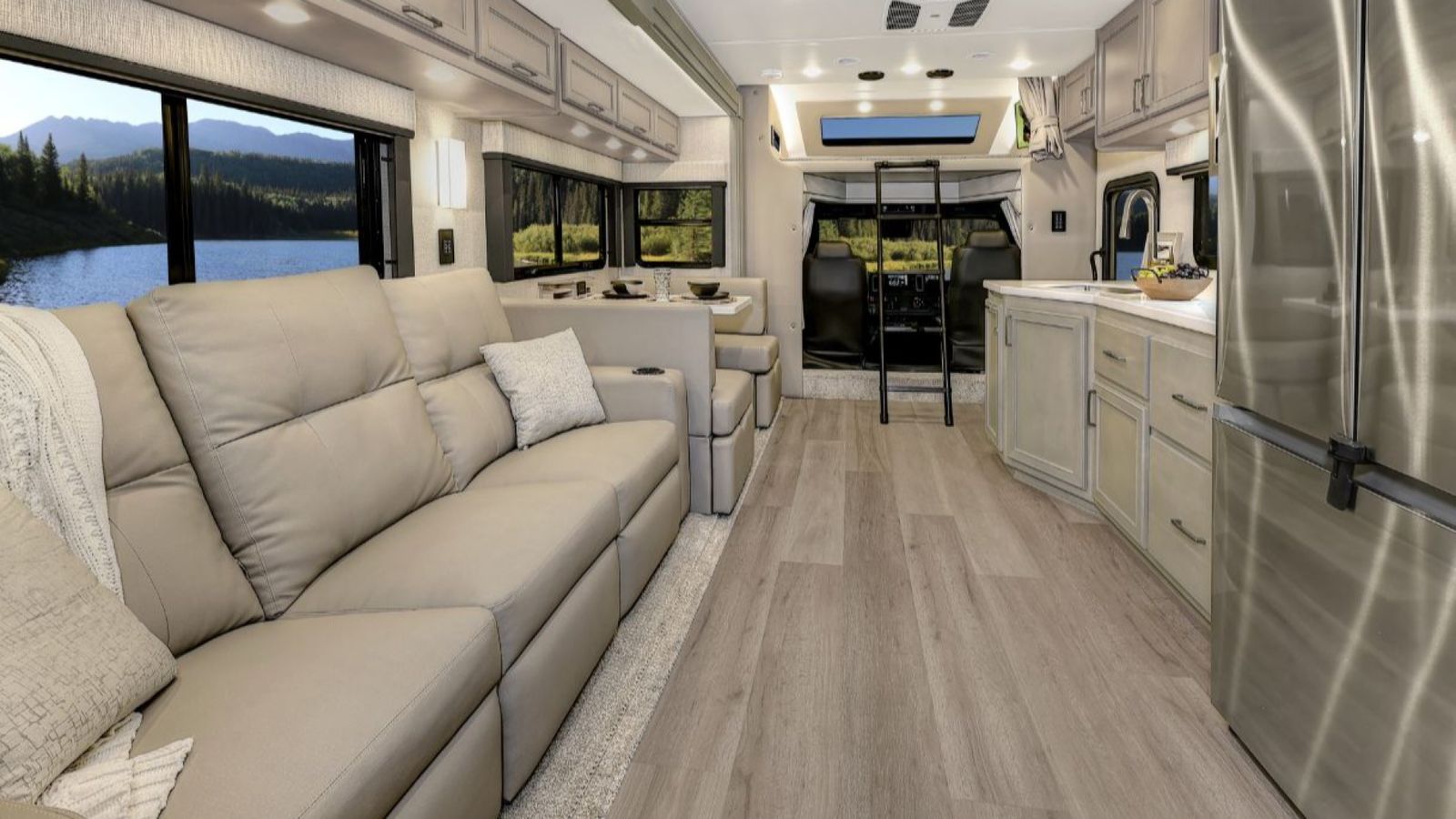 Interior of the 2026 Renegade Verona showing sofa, dinette, kitchen, and cab with overhead bunk.