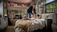 Woman makes a bed inside an RV
