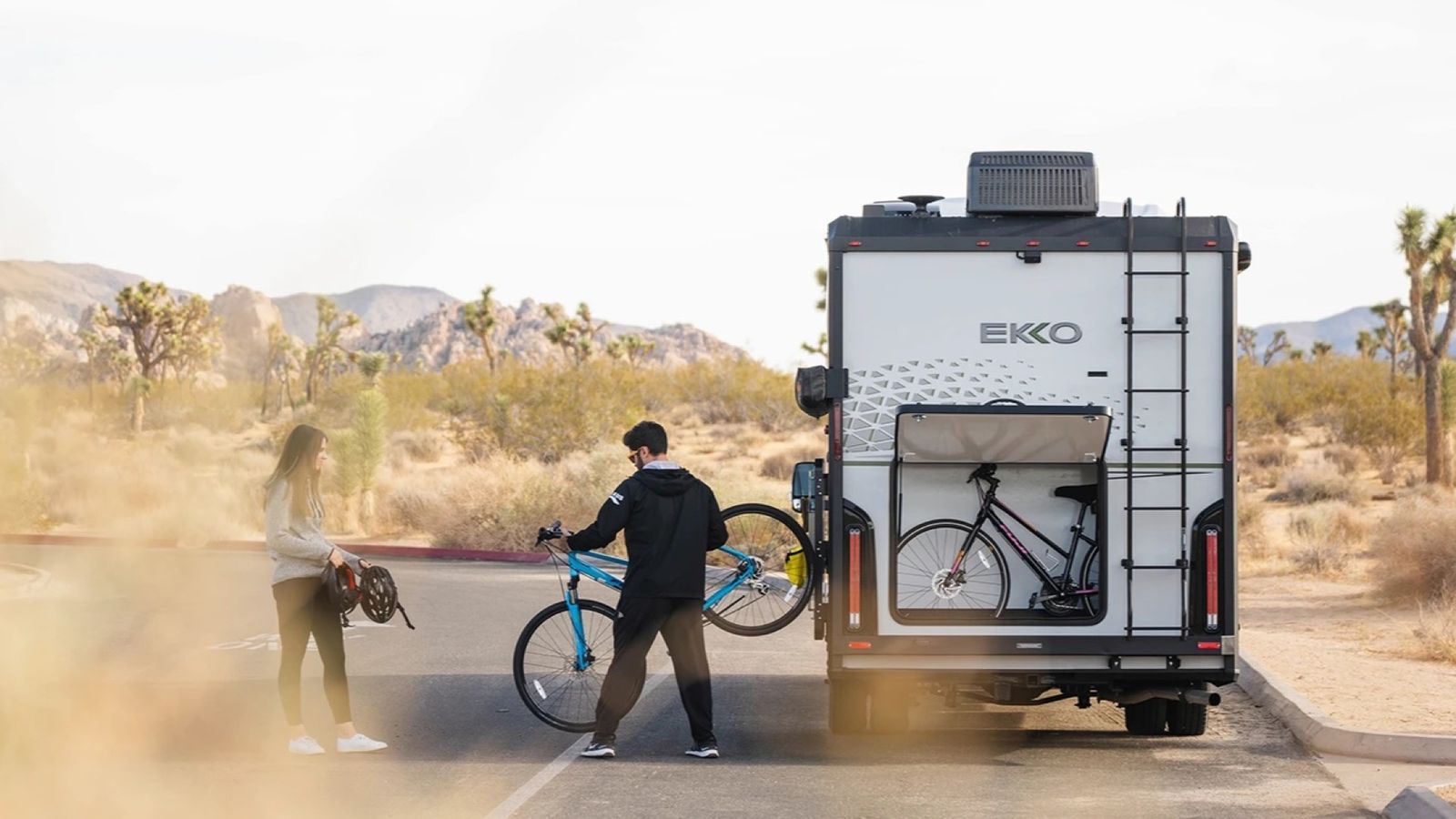 Couple unloading bikes from the EKKO in a desert scene