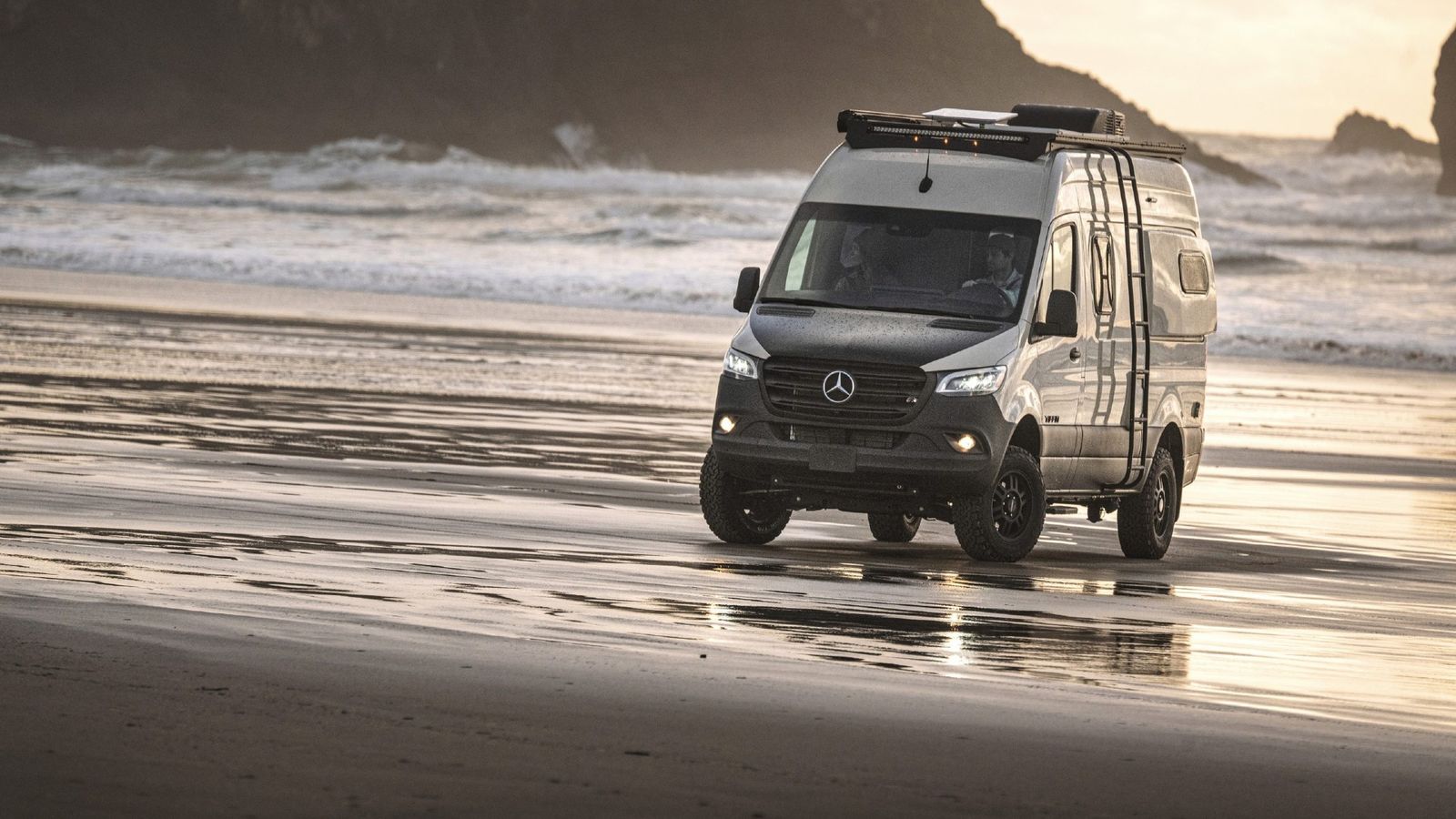 A 2025 Tiffin GH1 drives on a beach 