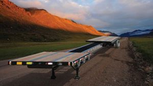 Trailer on a gravel road next to a mountain