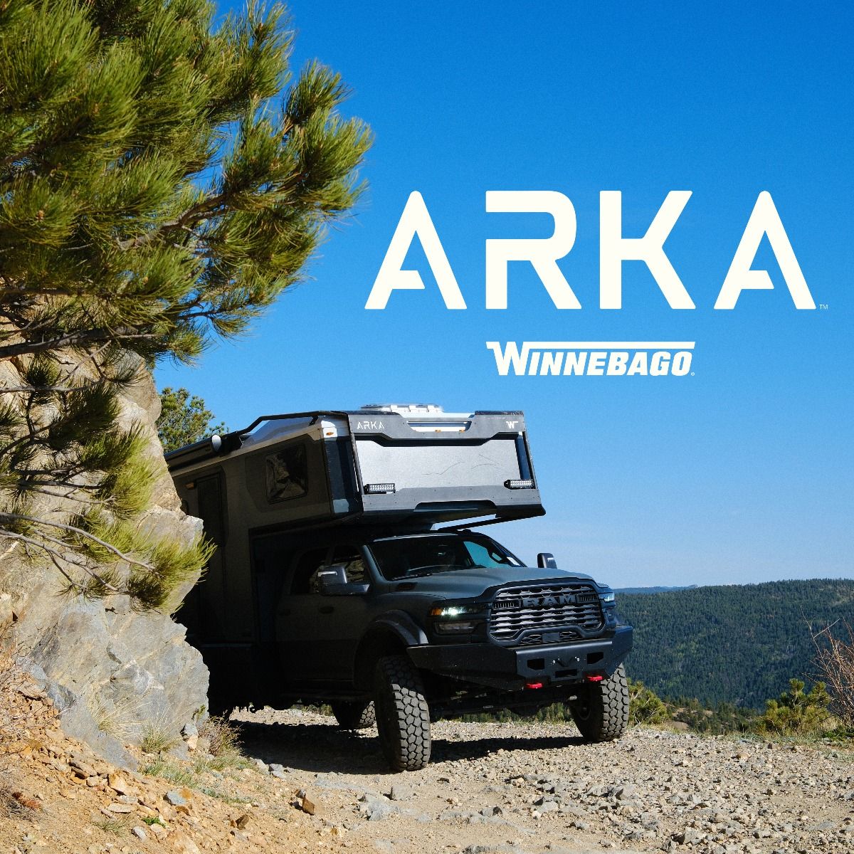 2027 Winnebago Arka driving through the mountains on a dirt road