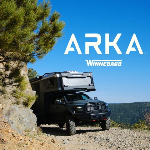 2027 Winnebago Arka driving through the mountains on a dirt road