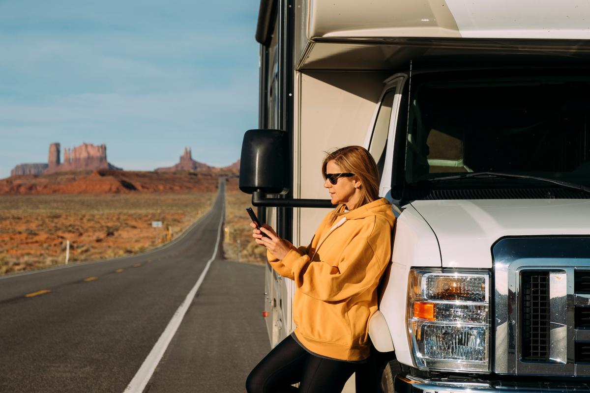 A woman leaning against an RV